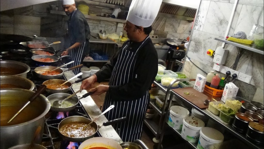 A chef making food in a restaurant kitchen. Order management is easier with RESTAURANT KDS (Kitchen Display System).