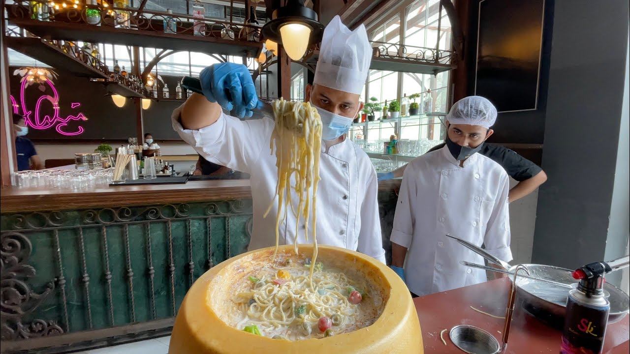entertain customers by making cheese wheel pasta