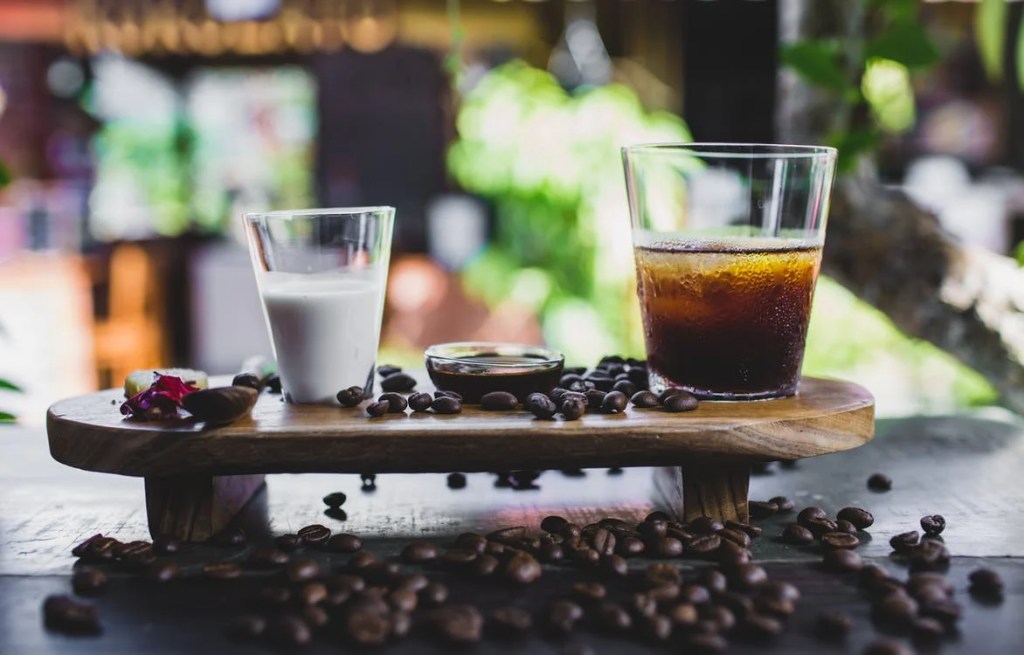 Cold brew coffee kept on a stand with a glass of milk. 